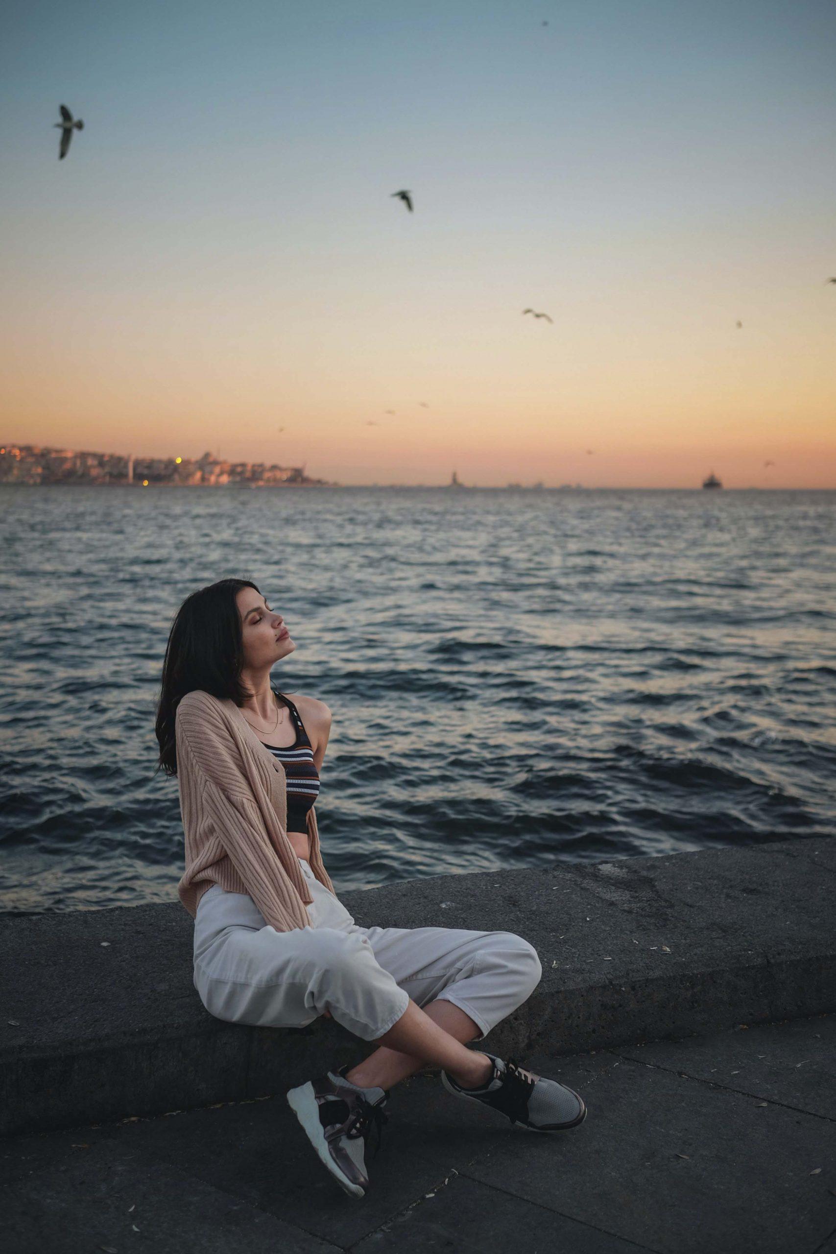 cô gái ngồi trước biển suy nghĩ về lòng tin