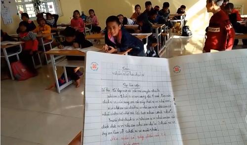 Thầy giáo đọc bài văn tả chiếc tivi của học sinh. 